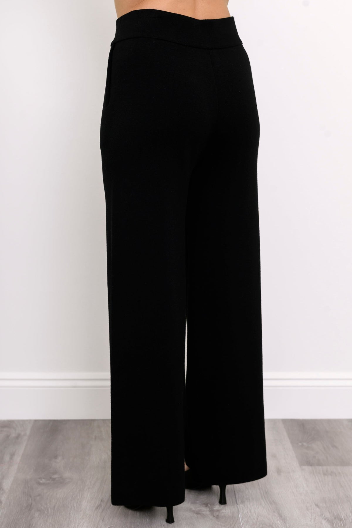 Rear view of onyx casual trousers, highlighting a comfortable flat waistband and pocket-free back panel design.