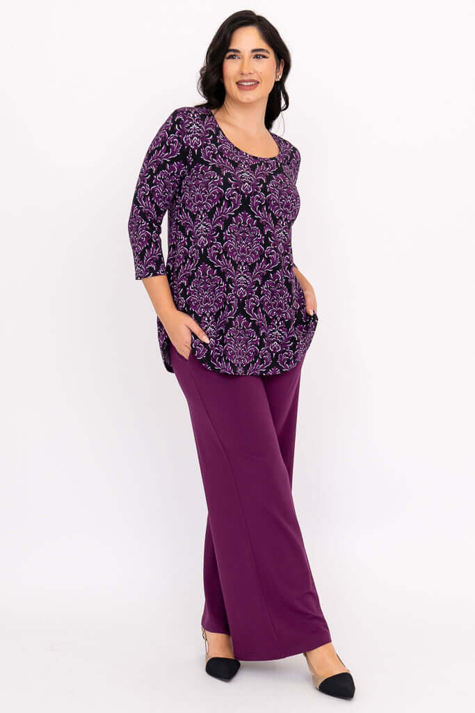 Side view of Jazz 3/4 Sleeve Top in Damask Purple, hands in pockets, purple pants