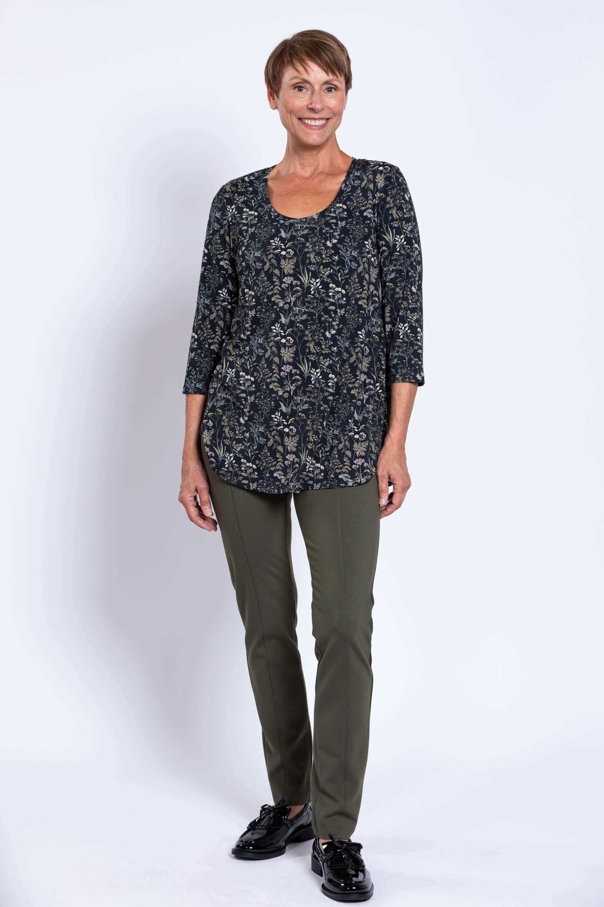 Woman standing in Jazz 3/4 bamboo top, forest floral, shown from the front