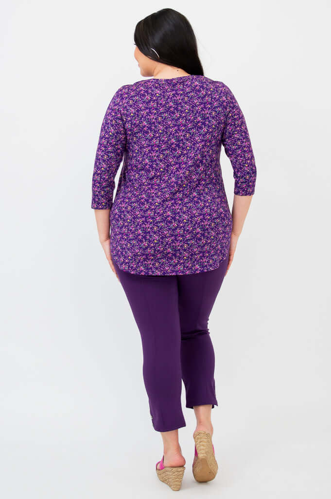 Back view of woman in purple floral 3/4 sleeve bamboo top and purple pants