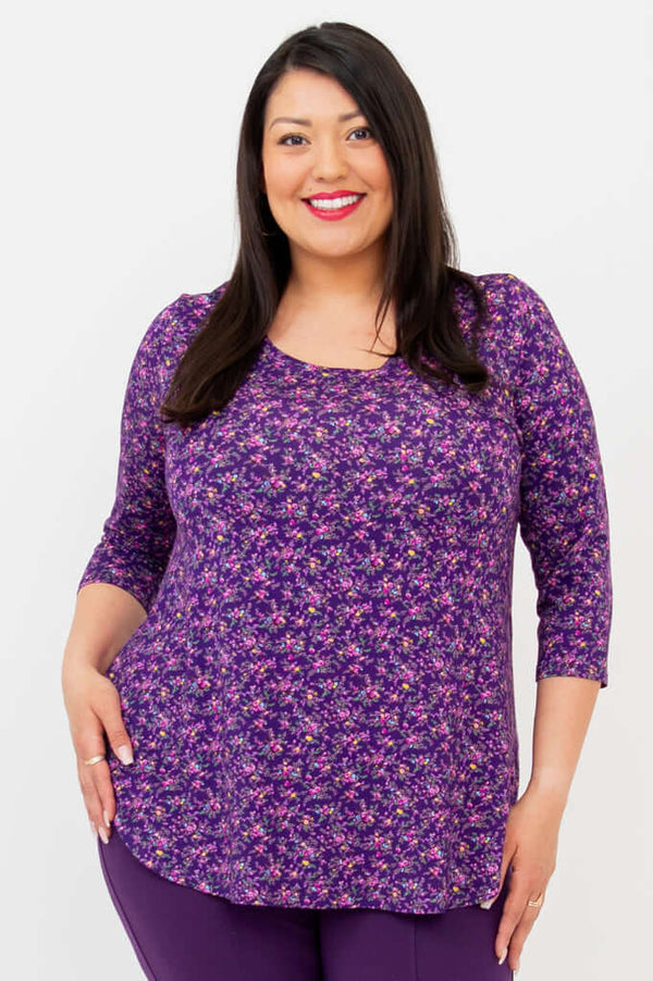 Woman wearing a purple floral 3/4 sleeve bamboo top, smiling confidently