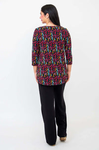 Back view of model wearing Jazz 3/4 sleeve top with multicolor abstract pattern and black pants