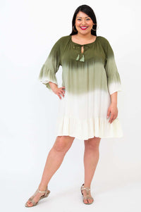 Woman wearing an olive green to white ombre dress with 3/4 ruffled sleeves and tassel tie