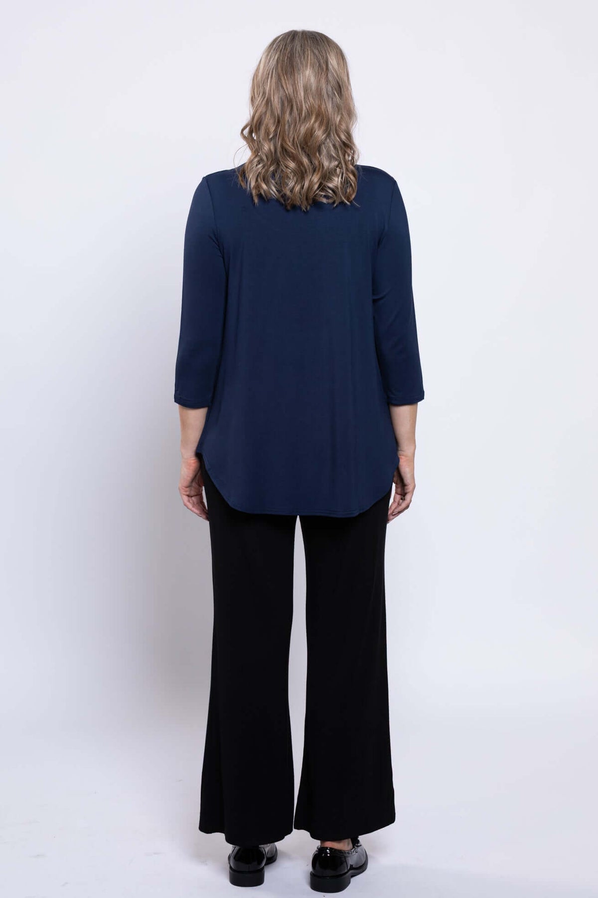 Back view of a woman wearing a navy 3/4 sleeve scoop neck top