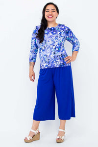 Model in Margorie blue floral tee and pants, posing with hand on hip