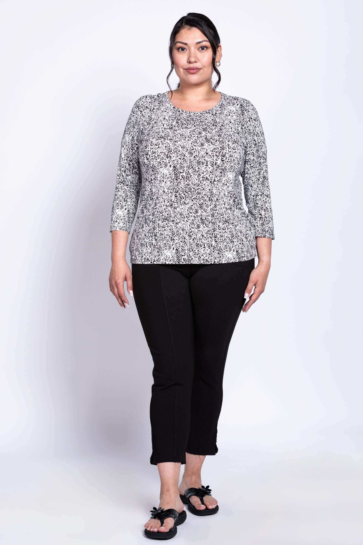 Plus size woman modeling black and white rose print 3/4 sleeve tee