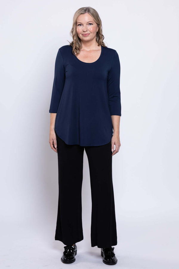 Full front view of a woman in a navy 3/4 sleeve top and black pants