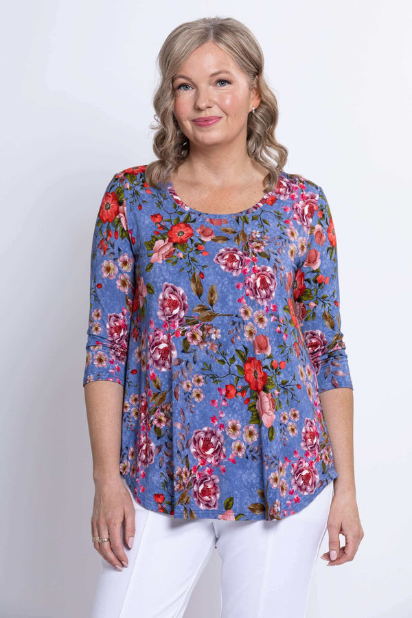 Woman wearing a blue floral 3/4 sleeve top, close-up view