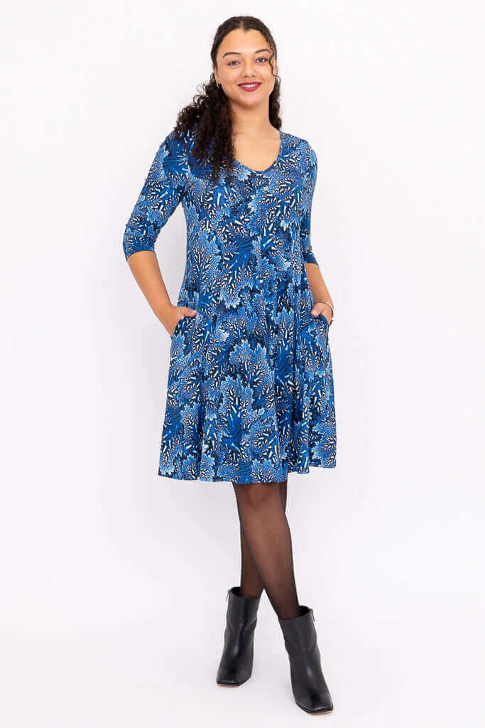 Front view of model wearing blue floral fit and flare dress with 3/4 sleeves