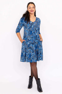 Front view of model wearing blue floral fit and flare dress with 3/4 sleeves