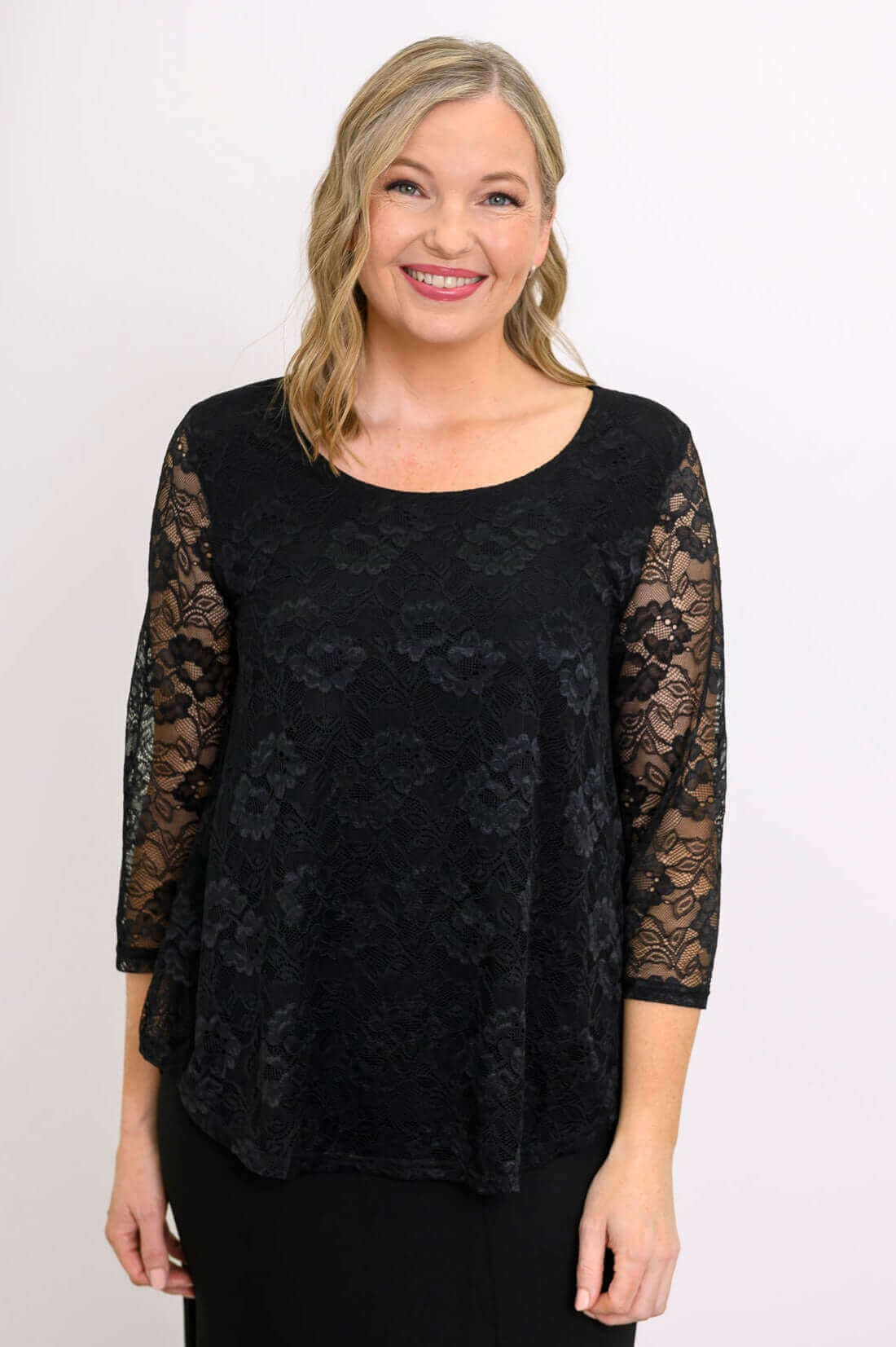 Close-up of woman wearing black lace top with 3/4 sleeves and scoop neckline