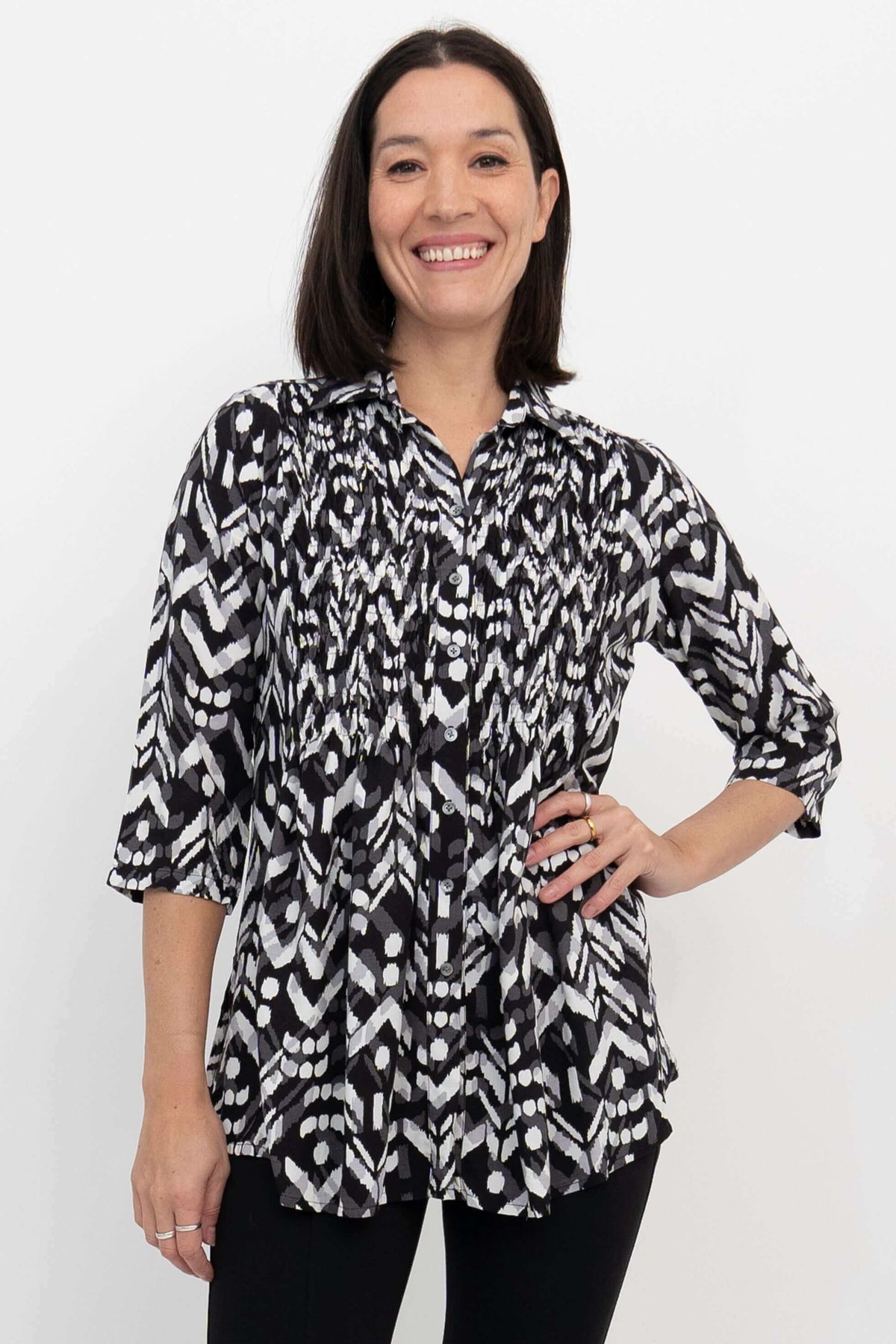 Front close-up of model wearing black and white smocked bodice blouse with 3/4 sleeves