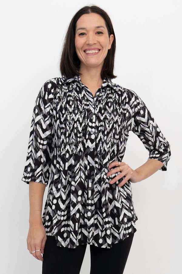 Front close-up of model wearing black and white smocked bodice blouse with 3/4 sleeves