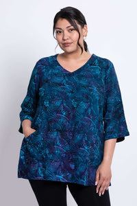 Closeup of model wearing Evelyn Top in lagoon blue with abstract print, V-neck and 3/4 sleeves