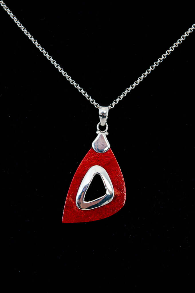 Close-up of a 925 sterling silver necklace featuring a modern red teardrop pendant