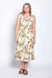 Woman posing in sleeveless tropical print midi dress with A-line silhouette