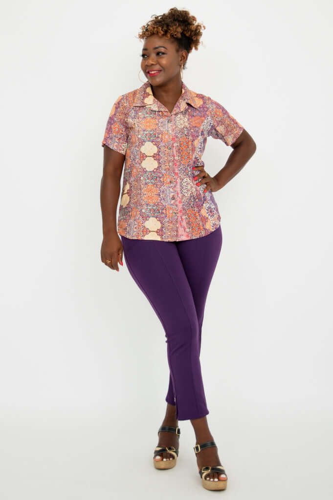 Woman in Aida Top posing with hand on hip and purple pants