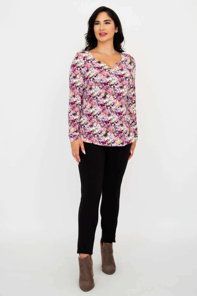 Woman standing at an angle in floral sweetheart neckline bamboo top and black pants