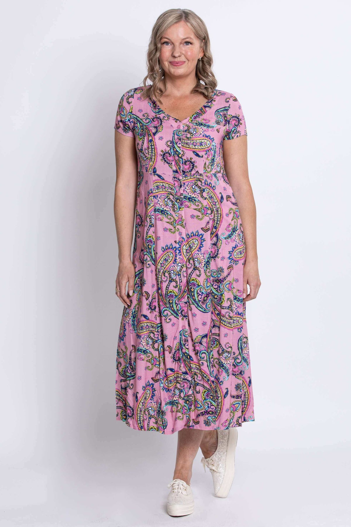 Angled front view of a woman in a pink paisley print dress with relaxed fit