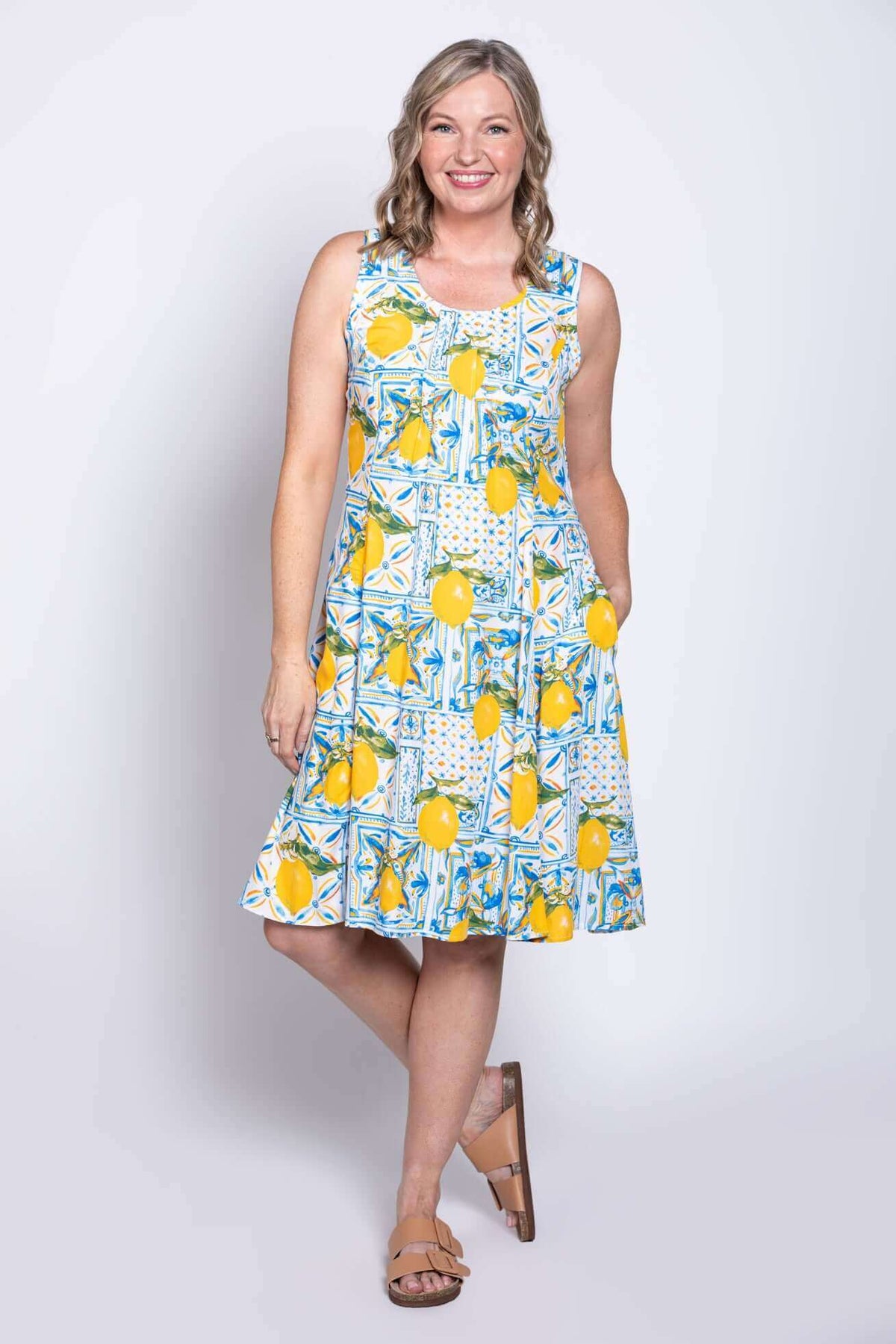 Model wearing sleeveless Arden dress, hand in pocket, front angle view