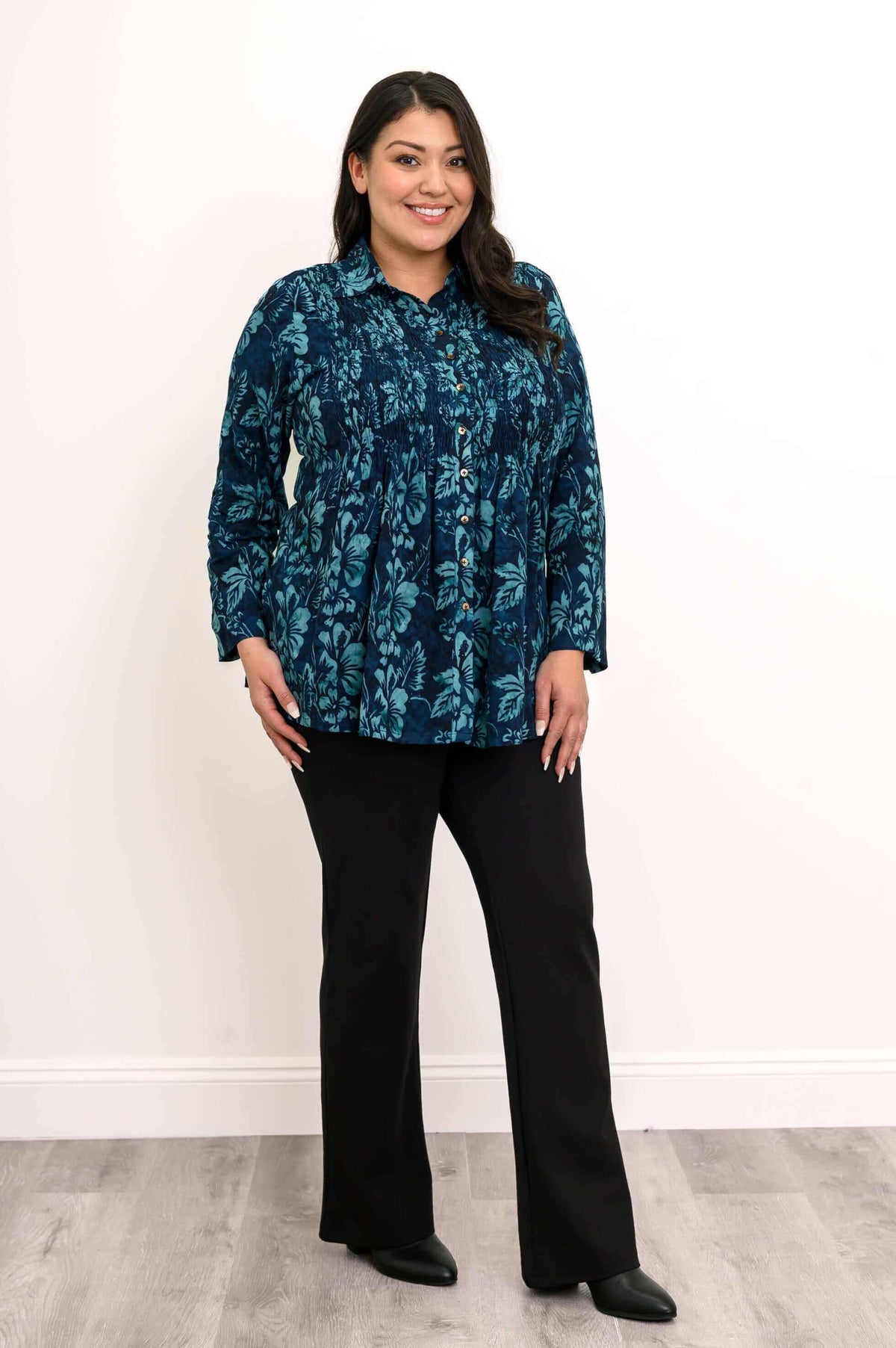 Woman in The Cindy blue floral smocked top, angled front view