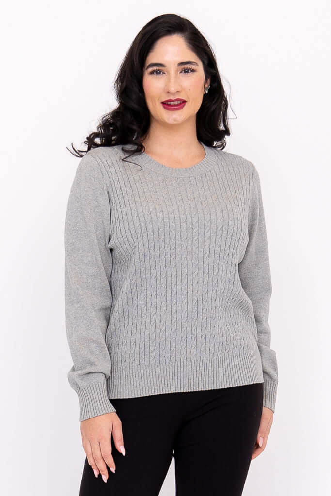 Angled front view of woman in a grey cable knit sweater