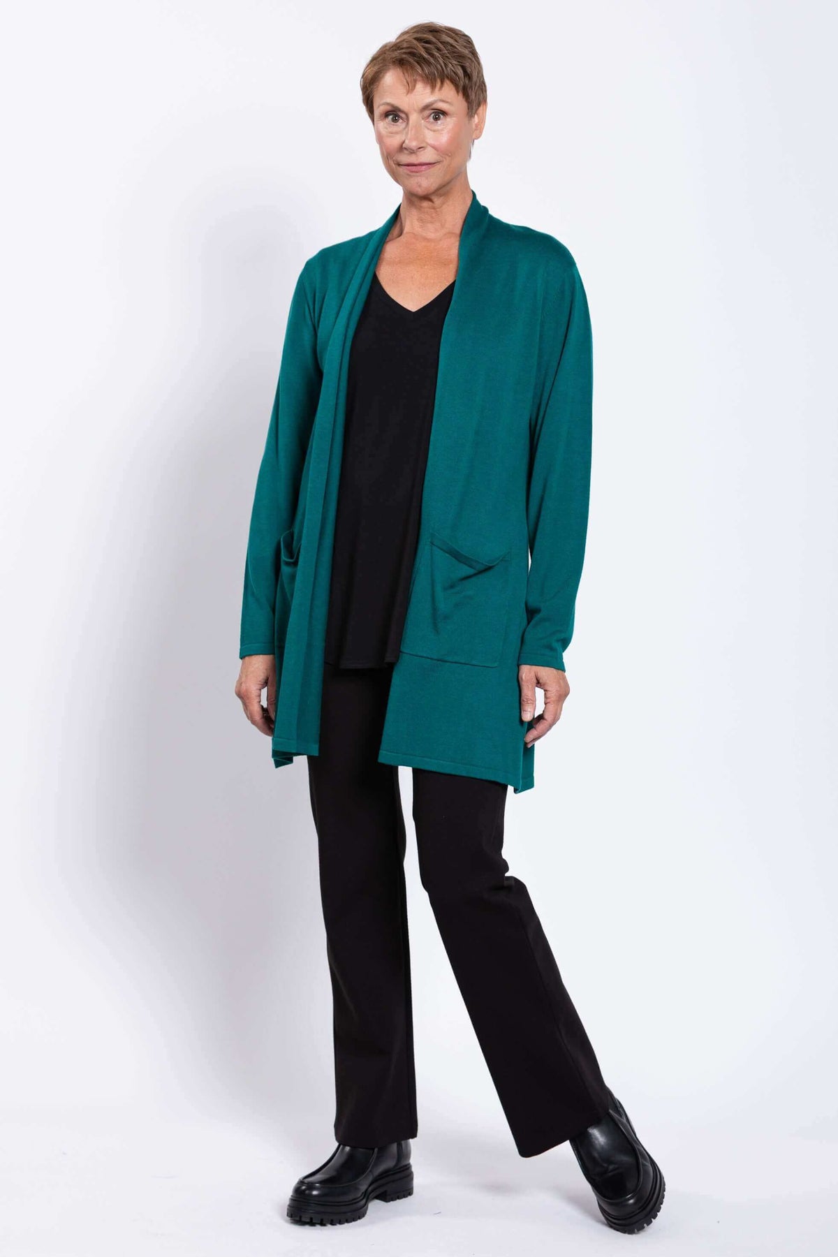 Woman standing in teal Paige Sweater cardigan, angled pose