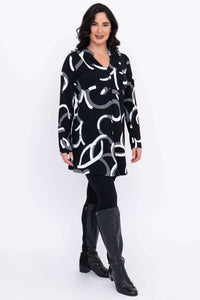 Angled view of Edwina tunic with bold abstract print, worn over leggings and boots.