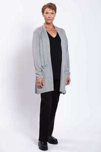 Woman modeling light grey cardigan with an open front and patch pockets, angled view