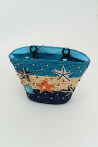 Angled view of multicolor rattan tote with decorative stars and beaded trim