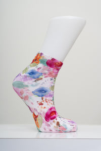 Vibrant pink watercolor floral pattern ankle sock on a white mannequin foot model against a light gray background.