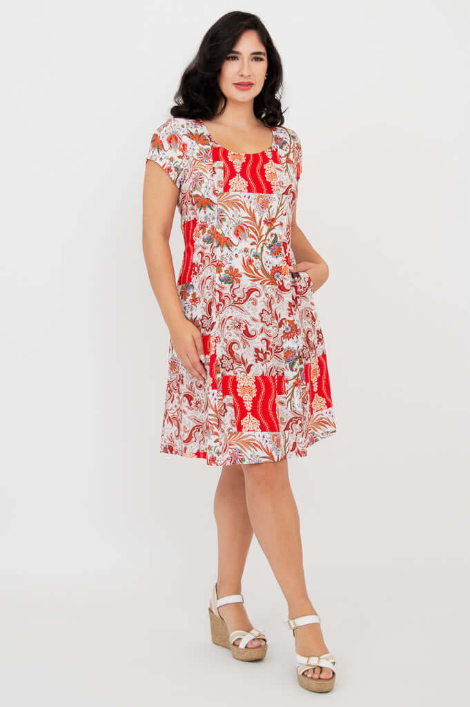 Anna dress in red paisley print, model with hand in pocket, angled pose