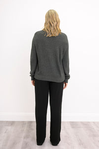 Back view of a slate-colored cable-knit sweater, highlighting continuous plaited details and a straight hem.