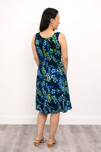 Back view woman wearing blue and green floral patterned sleeveless dress on a white background