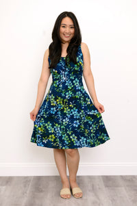 Front view woman wearing blue and green floral patterned sleeveless dress on a white background