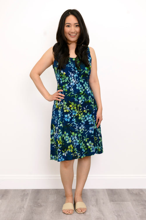 Front view woman wearing blue and green floral patterned sleeveless dress on a white background