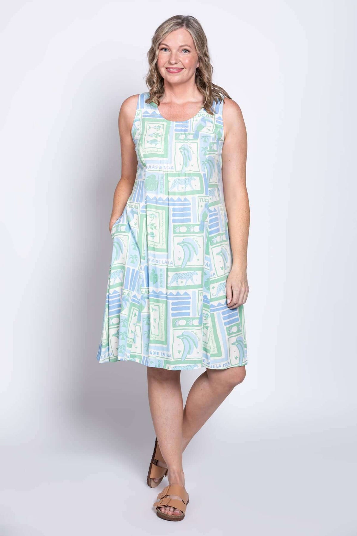 Woman posing with hands in pockets in a pastel graphic sleeveless A-line dress