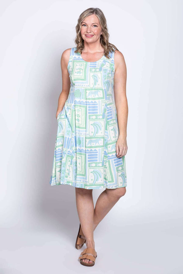 Woman posing with hands in pockets in a pastel graphic sleeveless A-line dress
