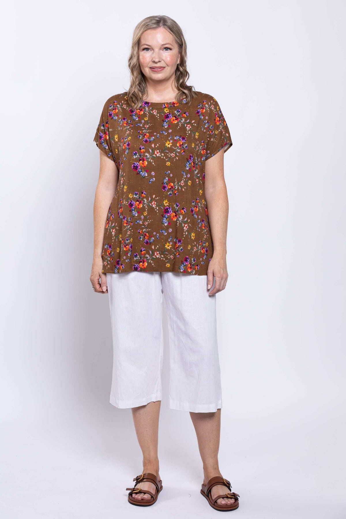 Back view of model wearing Aria Tee in brown floral print with dolman sleeves