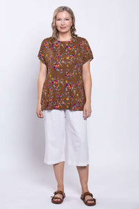 Back view of model wearing Aria Tee in brown floral print with dolman sleeves