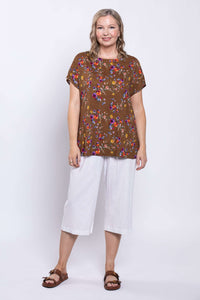 Full front view of model in brown floral Aria Tee and white pants