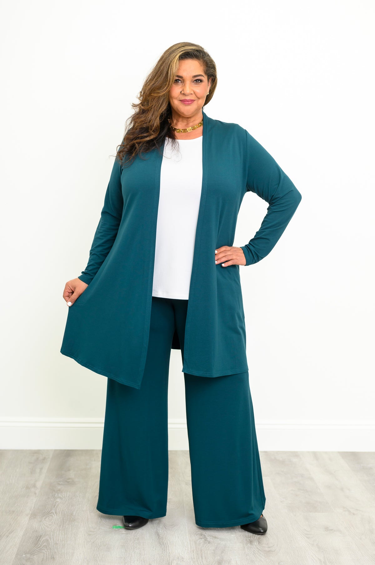 Straight-on full body view of a women's teal French terry duster jacket styled with wide-leg trousers.
