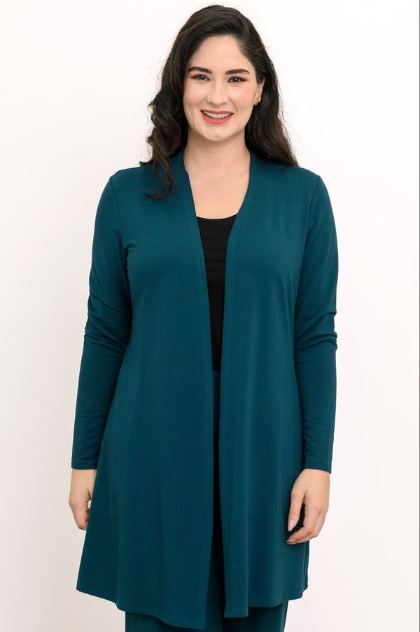 Front view portrait of a smiling woman wearing an open crystal teal long-line cardigan layered over a black top.