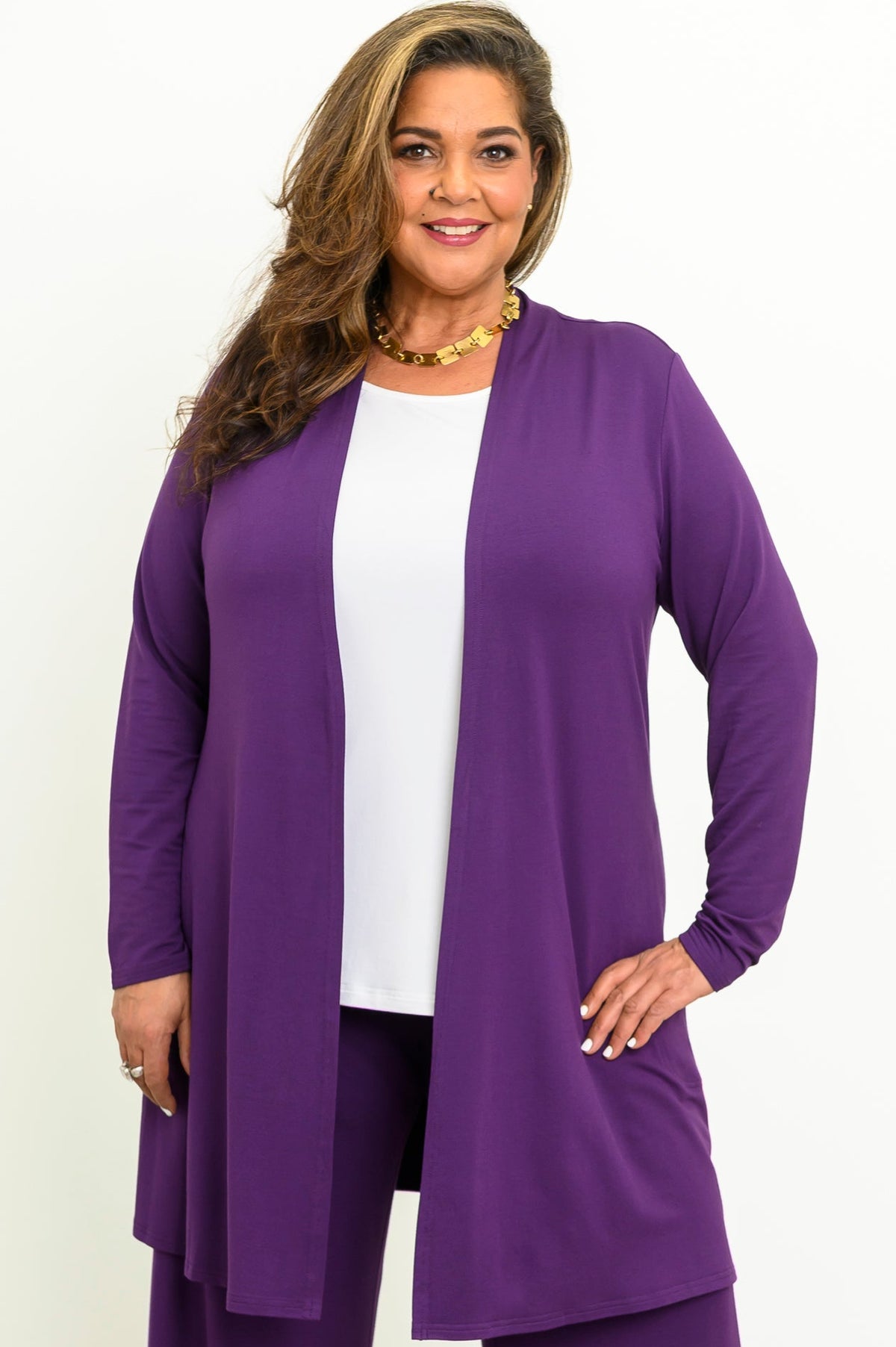 Front view of a smiling woman wearing an open royale purple long-line bamboo cardigan over a white top.
