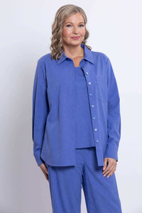 Woman wearing an azure blue relaxed button-up shirt with matching pants, front view