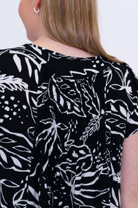 Back neckline and gathers detail on black and white leafy print dress