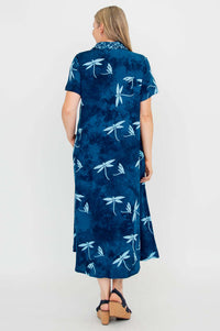 Back view of woman in a blue short sleeve dress with dragonfly motif and flared hem