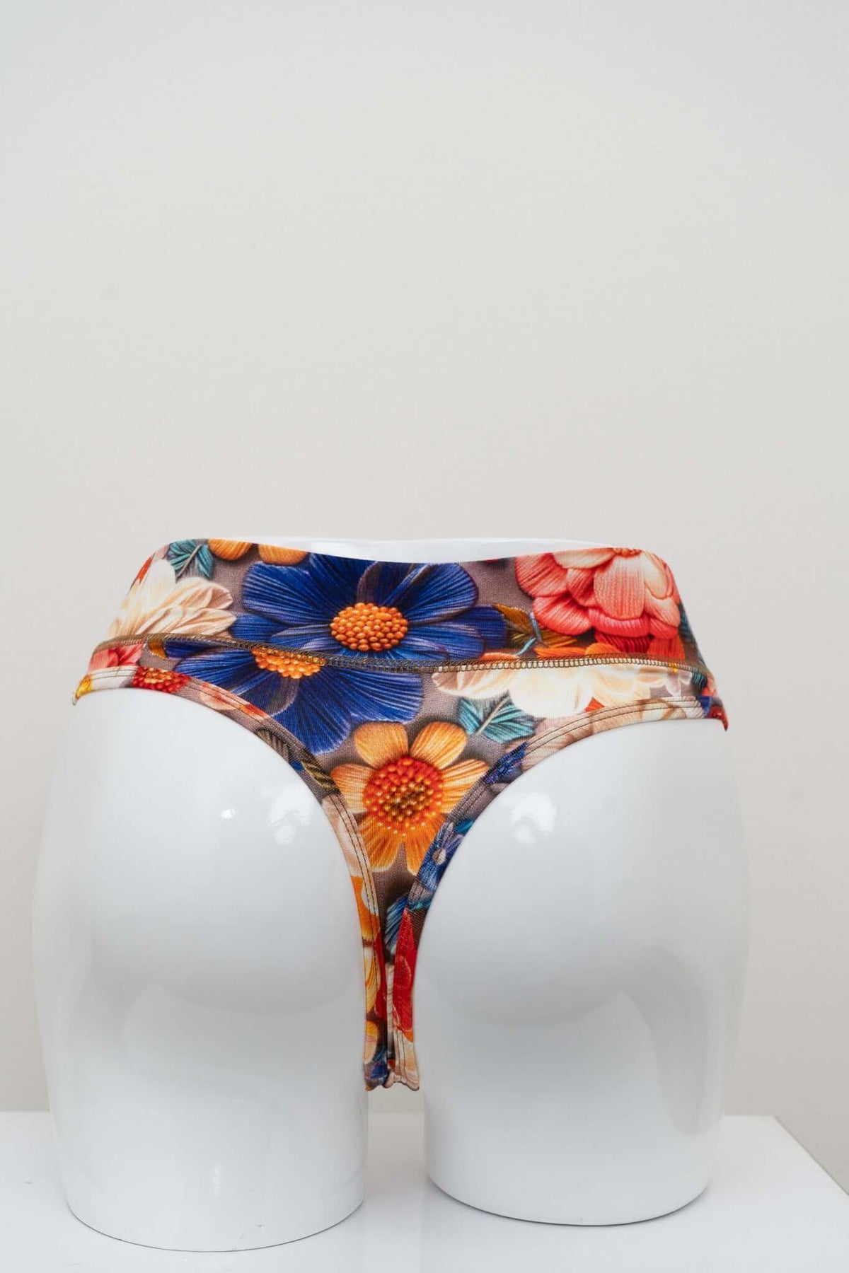 Back view of high rise thong underwear in vibrant floral bamboo fabric on a white mannequin