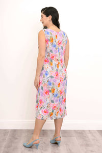 Back view of woman showcasing floral shift dress and blue heels
