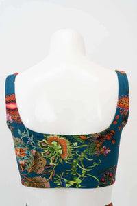 Back view of teal floral crop top with colorful floral print on mannequin